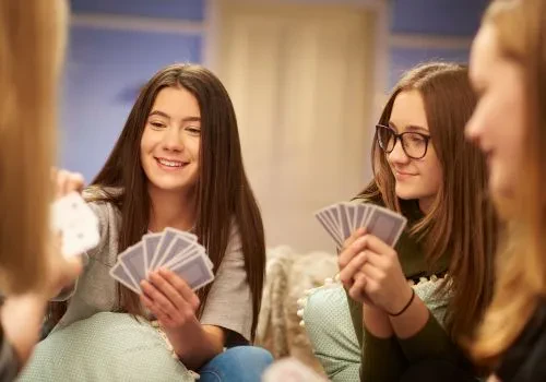 4 girls having fun playing cards
