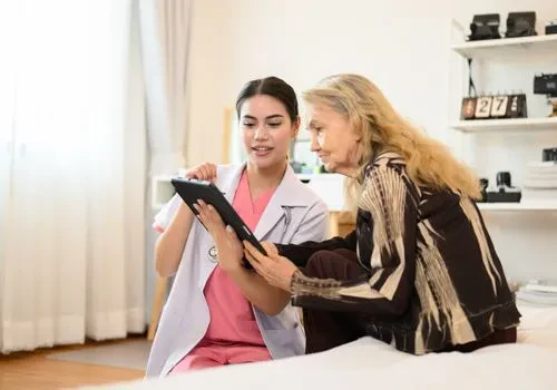 A doctor is showing a female nursing home resident her tablet