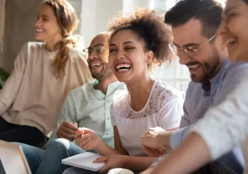 Four coworkers laughing together during a work break