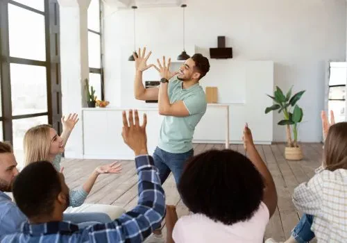 A group of colleagues playing a game of charades at work