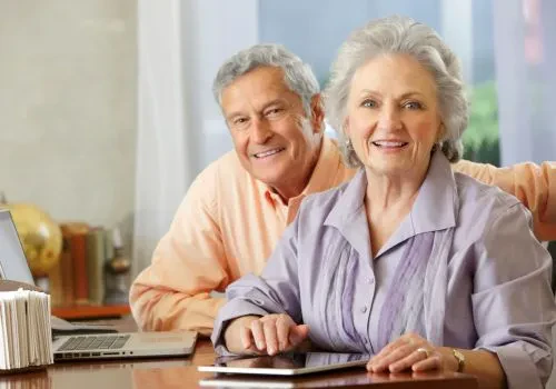A pair of senior citizens smiling at the camera.